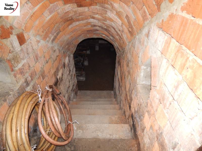  Na predaj 3 izbový dom v Kravanoch nad Dunajom s garážou . - Tehlová pivnica pod rodinným domom s dolu vedúcimi schodmi a zrolovanými hadicami na stene.