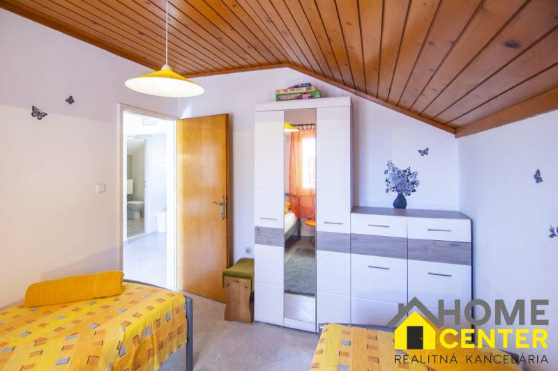 Na predaj krásny priestranný dom / 101 m²/ výhľadom na more  Čiovo - Spálňa v Rekreačnom apartmáne s farebným obliekaním, skrinkou a dekoráciami na stene.