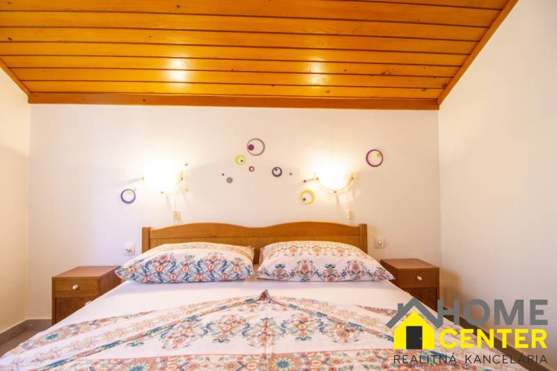 Na predaj krásny priestranný dom / 101 m²/ výhľadom na more  Čiovo - Spálňa v Rekreačnom apartmáne s posteľou a dekoráciami na bielej stene.