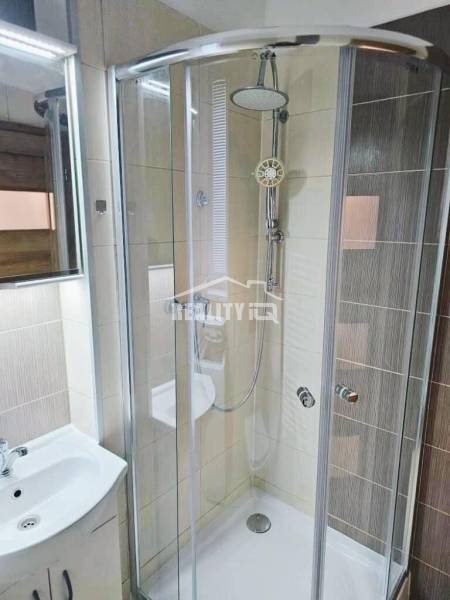 Prenájom, Garsónka, M.R.Štefánika, Centrum, Žilina - Kúpeľňa s preskleným sprchovacím kútom a svetlými dlaždicami v garsónke.