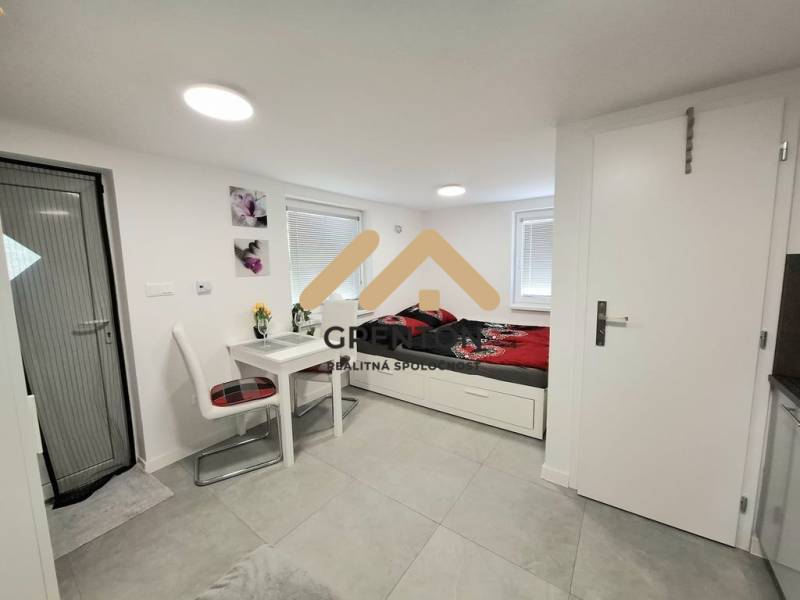 Záhrada s Tiny House, Zlaté piesky, dobrá poloha a dostupnosť - Interiér chaty s jedálenským stolom, stoličkami a posteľou na svetlej podlahe.