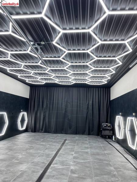 Ponuka na odstupenie detailingového štúdia a autoumyvárne v Prievidzi - Obchodné priestory s tmavým dekorom a šesťuholníkovým LED osvetlením na strope a stenách.
