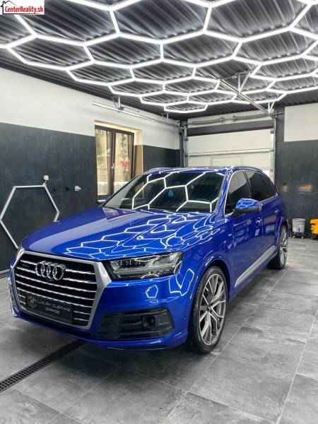 Ponuka na odstupenie detailingového štúdia a autoumyvárne v Prievidzi - Audi SUV v obchodných priestoroch s kachličkovou podlahou a geometrickými stropnými svetlami.