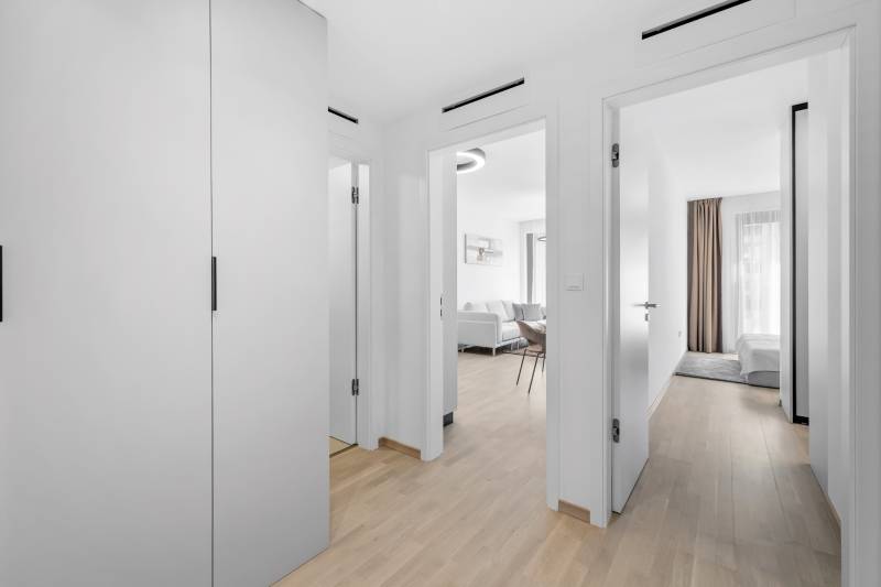 I Prenájom exkluzívneho 2-i bytu v projekte Metropolis - Chodba v 2-izbovom byte s podlahou s dreveným dekorom a dvomi miestnosťami.