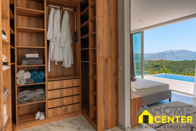 NA PREDAJ Luxusná vila  /360 m²/ s infinity bazénom, mesto Korčula - Šatník vo vile s výhľadom na more, podlaha s dreveným dekorom, bazén.