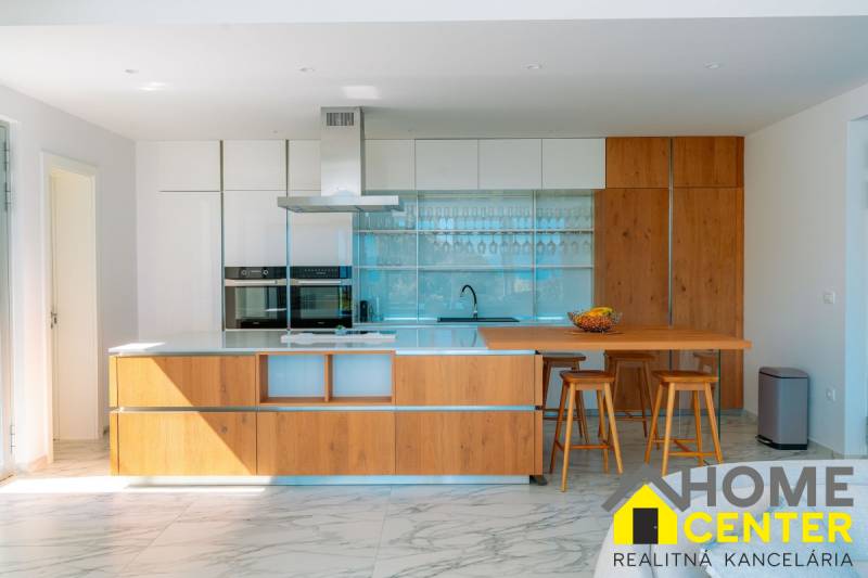 NA PREDAJ Luxusná vila  /360 m²/ s infinity bazénom, mesto Korčula - Kuchyňa vo vile s podlahou s dreveným dekorom, ostrovčekom a barovými stoličkami.
