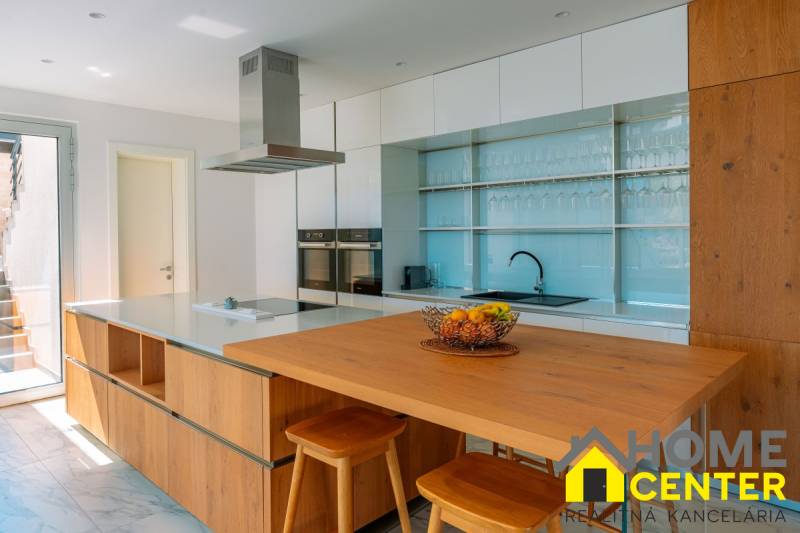 NA PREDAJ Luxusná vila  /360 m²/ s infinity bazénom, mesto Korčula - Kuchyňa vo vile so stolom z dreveného dekoru a ovocím v miske.