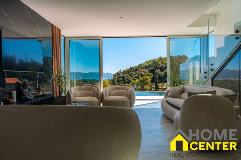 NA PREDAJ Luxusná vila  /360 m²/ s infinity bazénom, mesto Korčula - Interiér Vily s veľkými oknami, pohľad na zeleň a bazén.