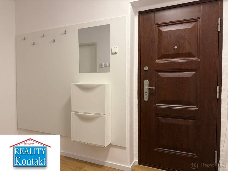Na prenájom 2-izbový byt  Nové Zámky - Vstupná hala v 2-izbovom byte s tmavými dverami a podlahou s dreveným dekorom.