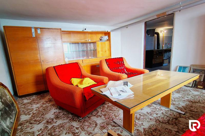 Rodinný dom v obci Borskom Mikuláš. - Obývacia izba v rodinnom dome so staršími kreslami, stolom a presklenou skriňou.