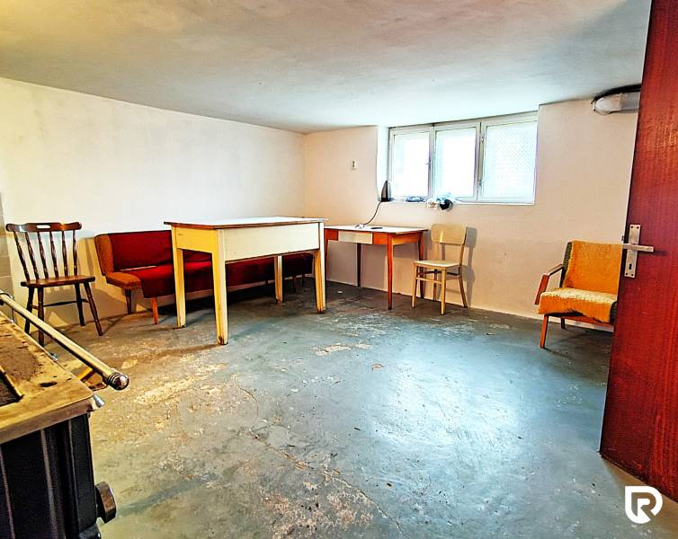 Rodinný dom v obci Borskom Mikuláš. - Pivnica v rodinnom dome s nábytkom a oknom, betónová podlaha.