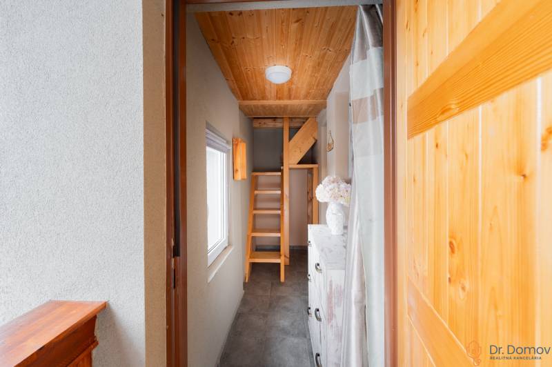 Záhradná chatka Handlová - Svetlá chodba v chate s drevenými schodmi a dekoratívnymi prvkami.
