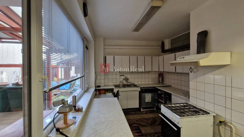 AstonReal: EXKLUZÍVNE predaj rodinný dom Spišská Nová Ves - Ferčekovce - Kuchyňa v rodinnom dome so spotrebičmi, dlaždicami a oknom s výhľadom na terasu.