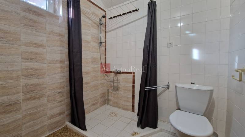 AstonReal: EXKLUZÍVNE predaj rodinný dom Spišská Nová Ves - Ferčekovce - Kúpeľňa v rodinnom dome s jednoduchým sprchovým kútom a svetlými obkladmi.