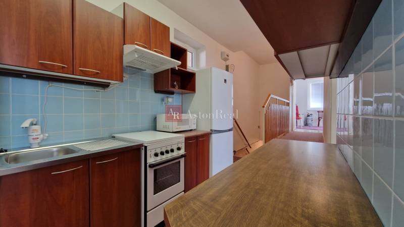 AstonReal: EXKLUZÍVNE predaj rodinný dom Spišská Nová Ves - Ferčekovce - Kuchyňa v rodinnom dome s dreveným dekorom, modrými obkladmi a kuchynskou linkou.