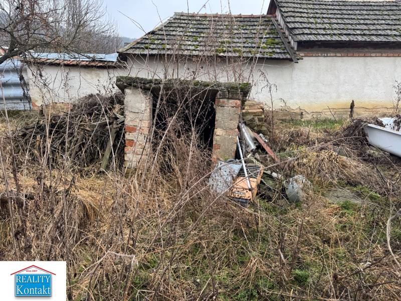 Predám pozemok v obci Dubník okr. Nové Zámky - Opustená budova na pozemku v Dubníku s neudržovaným okolím a starými strechami.