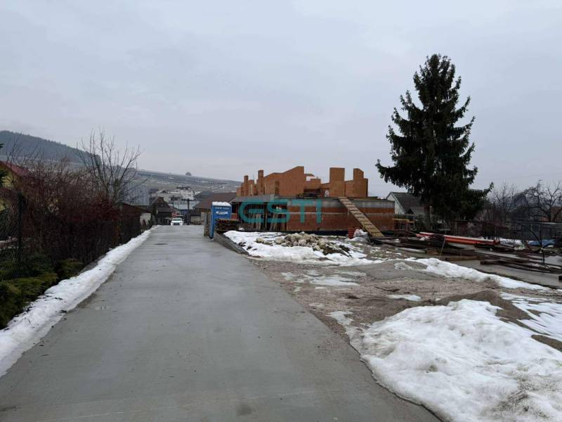 Novostavba - rodinný dom vo Višňovom pri Žiline - Stavenisko rodinného domu vo Višňovom na Višňovej ulici so zasneženým okolím a stromom.