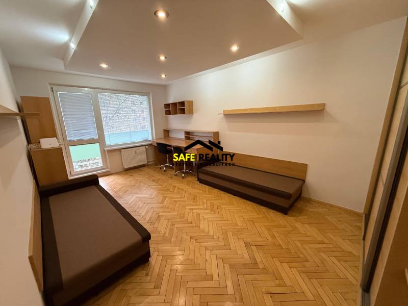 PRENÁJOM Trojizbový zariadený byt, Žilina - Vlčince - Obývačka v 3-izbovom byte s podlahou s dreveným dekorom a pracovným stolom.