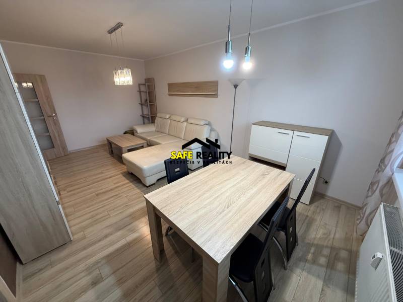 PRENÁJOM Trojizbový zariadený byt, Žilina - Vlčince - Obývacia izba s podlahou s dreveným dekorom, pohovkou a stolom v 3-izbovom byte.