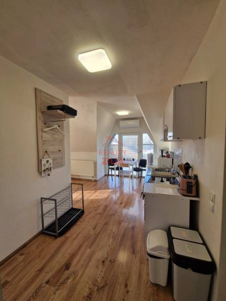 Viacgeneračný rodinný dom / investičná nehnuteľnosť – Dolná časť Zobor - Interiér rodinného domu s kuchyňou a jedálenským kútom, podlaha s dreveným dekorom.