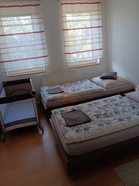 Viacgeneračný rodinný dom / investičná nehnuteľnosť – Dolná časť Zobor - Detská postieľka a dve postele v spálni s podlahou s dreveným dekorom.