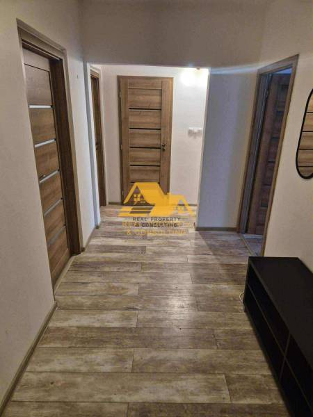 Prenajmem 3 izbový byt s loggiou v Nových Zámkoch - Chodba v 3-izbovom byte s podlahou s dreveným dekorom a viacerými dverami.