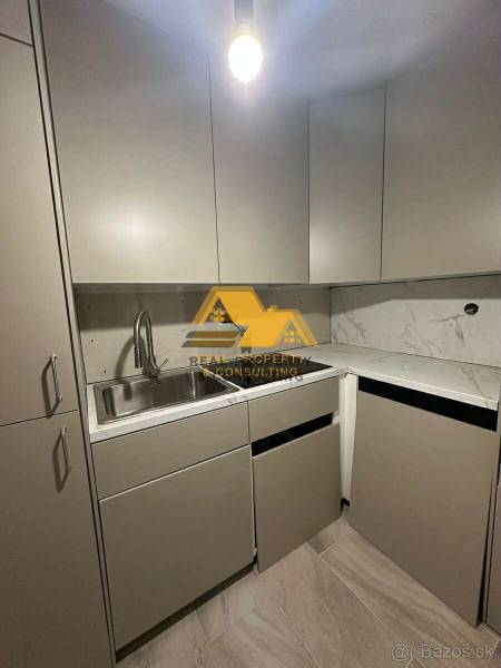 Prenajmem prerobený 2 izbový byt s balkónom v Nových Zámkoch - Kuchyňa v 2-izbovom byte s mramorovou doskou a sivými skrinkami.
