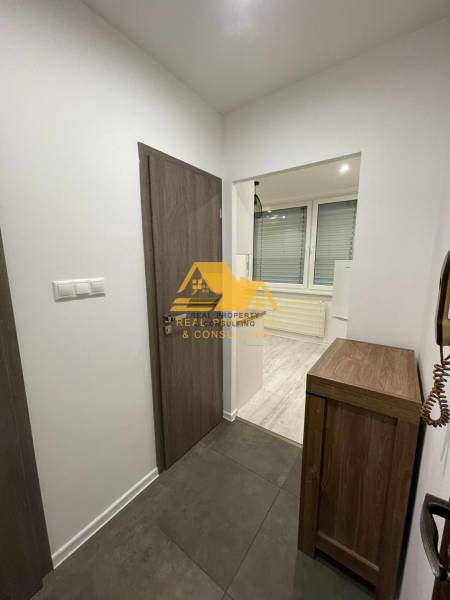 Prenajmem prerobený 1 izbový byt v Nových Zámkoch - Interiér 1-izbového bytu s dlažbou a podlahou s dreveným dekorom.