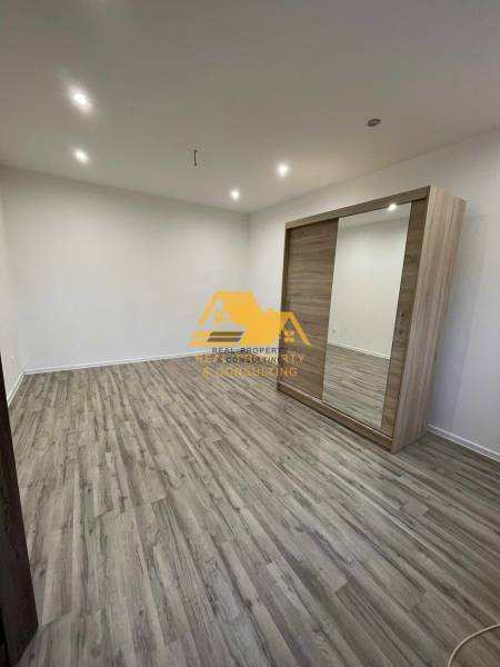 Prenajmem prerobený 1 izbový byt v Nových Zámkoch - Interiér 1-izbového bytu s podlahou s dreveným dekorom a vstavanou skriňou.