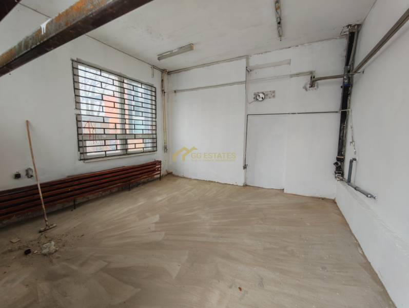 Prenájom Garáže na Hviezdoslavovej ulici. - Interiér garáží s oknom a mrežou, podlaha s dreveným dekorom.