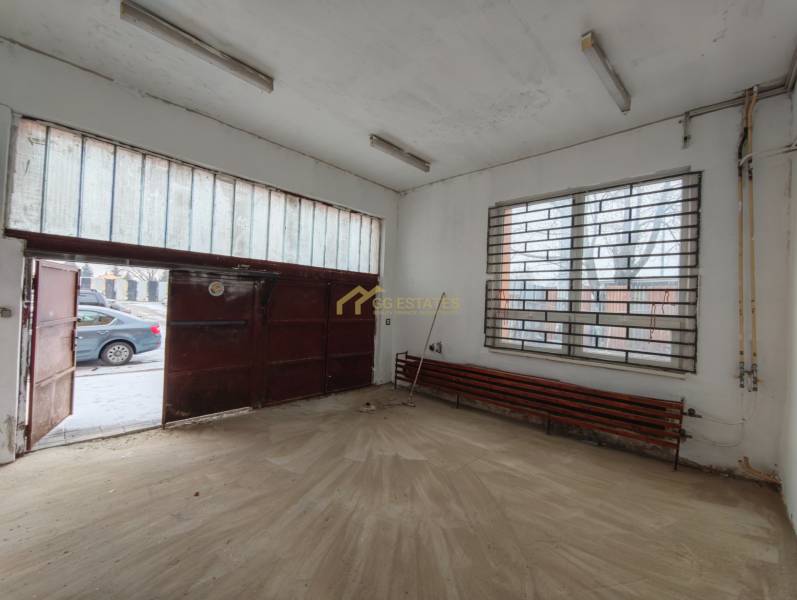 Prenájom Garáže na Hviezdoslavovej ulici. - Interiér garáže s podlahou s dreveným dekorom a kovovou bránou.