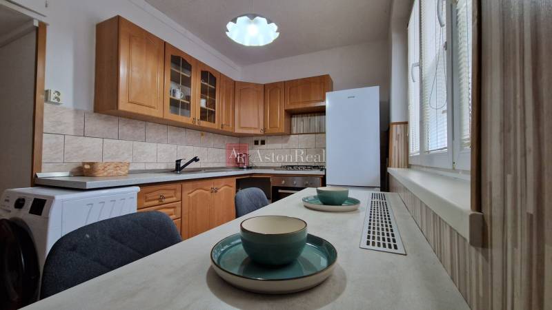 AstonReal:  predaj 2-izbový byt 54 m2, Poprad - Západ, Komenského - Kuchyňa s drevenými skrinkami a jedálenským stolom v 2-izbovom byte.