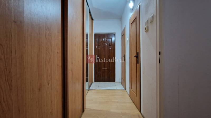 AstonReal:  predaj 2-izbový byt 54 m2, Poprad - Západ, Komenského - Chodba v 2-izbovom byte s podlahou s dreveným dekorom a vstavanou skriňou.