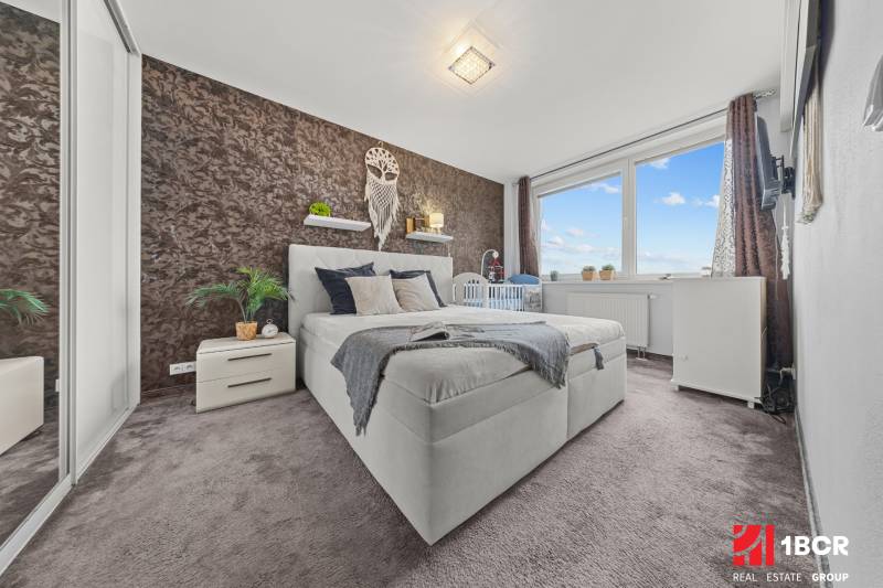 KOMPLETNE ZARIADENÝ 2-IZB. BYT,BALKÓN + PIVNICA,BUDATÍNSKA – PETRŽALKA - Spálňa v 2-izbovom byte s dvojlôžkom, kobercovou podlahou a dekoratívnou stenou.