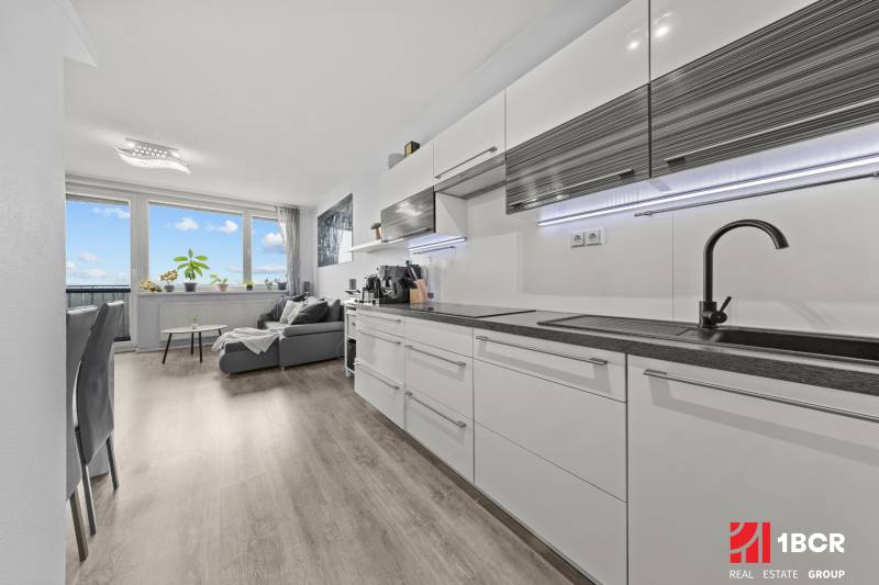 KOMPLETNE ZARIADENÝ 2-IZB. BYT,BALKÓN + PIVNICA,BUDATÍNSKA – PETRŽALKA - Kuchyňa a obývacia izba v 2-izbovom byte s podlahou s dreveným dekorom.