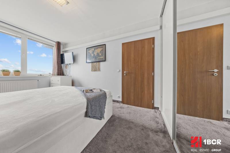 KOMPLETNE ZARIADENÝ 2-IZB. BYT,BALKÓN + PIVNICA,BUDATÍNSKA – PETRŽALKA - Svetlá spálňa s posteľou, veľkým oknom a šatníkovou skriňou v 2-izbovom byte.