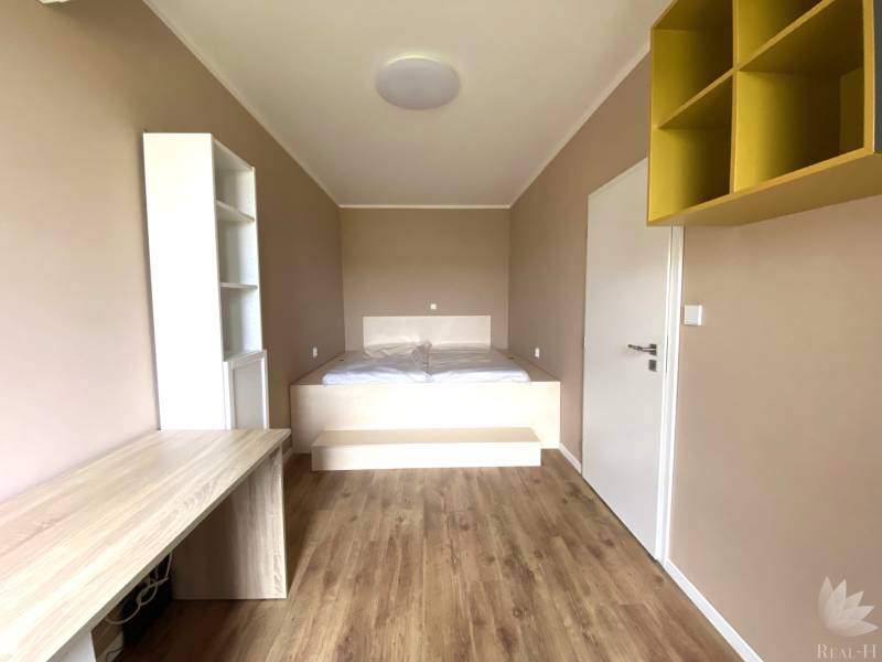 PRENÁJOM NÁDHERNÝ 3-IZBOVÝ BYT MAMAPAPA BA IV DÚBRAVKA - Izba v 3-izbovom byte s podlahou s dreveným dekorom a vstavaným stolom.