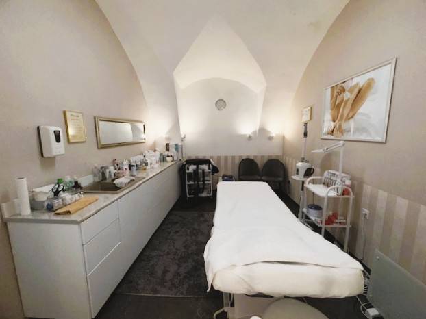 Prenájom obchodného priestoru, Hauptstraße, Hauptstraße, Eisenstadt - Obchodné priestory s masážnym stolom, zdravotníckymi pomôckami a dekoratívnym obrazom na stene.