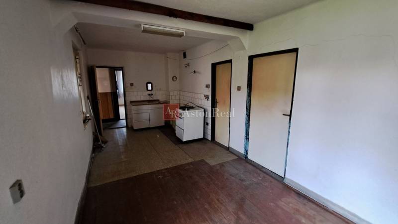 PREDAJ: Rodinný dom Kalameny s pozemkom 1.789m2 - Kuchyňa v rodinnom dome s linkou a podlahou s dreveným dekorom.