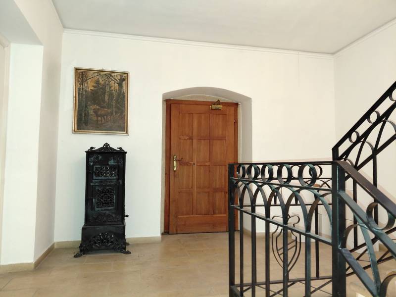 Prenájom kancelárie, Hauptstraße, Hauptstraße, Eisenstadt - Chodba v kancelárii s maľbou, drevenými dverami a kachľovou pecou.