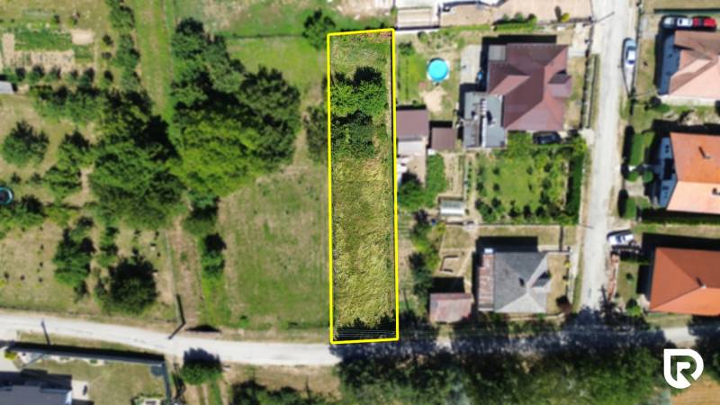 Stavebný pozemok 613m2 | Nitrianska Blatnica - Topoľčany - Letecký pohľad na pozemok pre bývanie v Nitrianskej Blatnici, lemovaný zeleňou.
