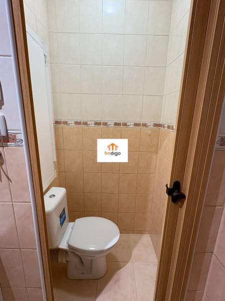 PRENÁJOM - 1 izbový byt v Šali na prenájom  - Toaleta v 1-izbovom byte s béžovými obkladačkami a drevenými dverami.