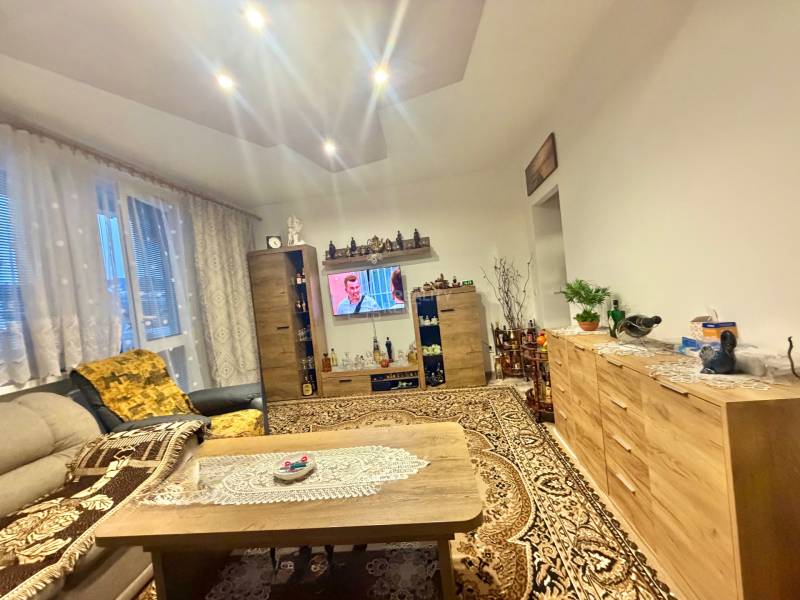 Predaj 2-izbového bytu v Krásne nad Kysucou - Obývacia izba v 2-izbovom byte s vkusným kreslom, televízorom a kobercom, podlaha s dreveným dekorom.