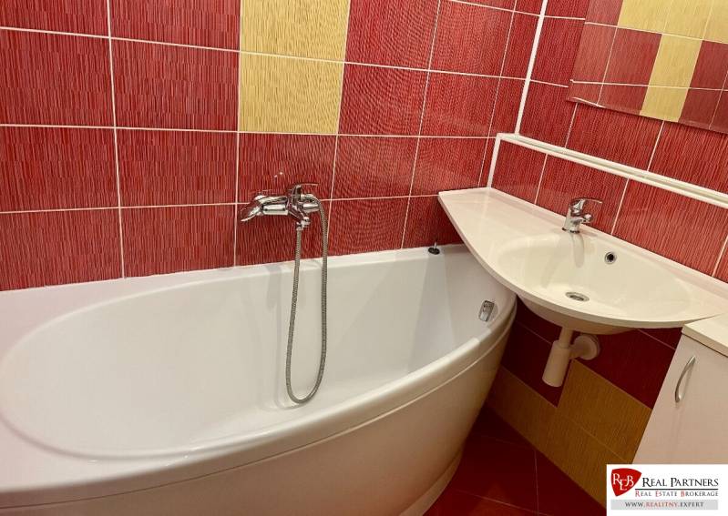 Prenájom 2-izb kompletne zariadený PET FRIENDLY byt BA II - Kúpeľňa v 2-izbovom byte s červenými a žltými kachličkami, vaňou a umývadlom.