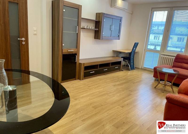 Prenájom 2-izb kompletne zariadený PET FRIENDLY byt BA II - 2-izbový byt so sedačkou, pracovným stolom a podlahou s dreveným dekorom.