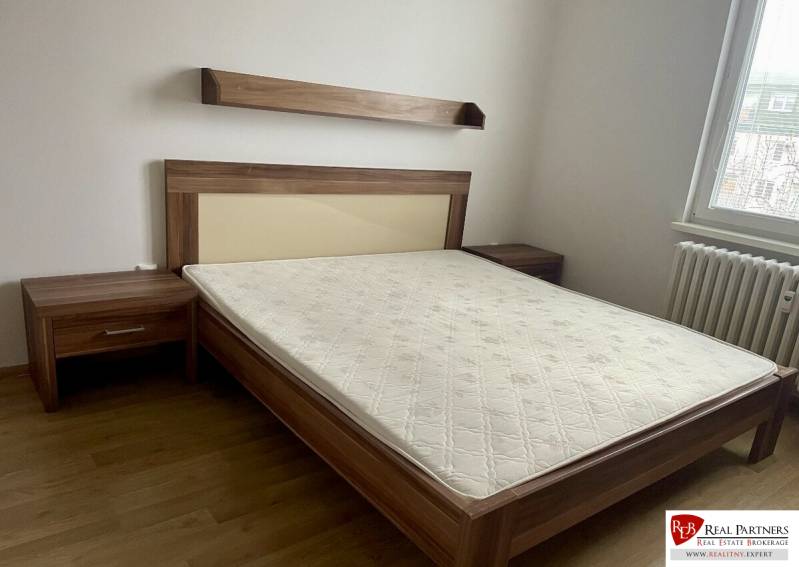 Prenájom 2-izb kompletne zariadený PET FRIENDLY byt BA II - Spálňa s posteľou, drevenými nočnými stolíkmi a podlahou s dreveným dekorom v 2-izbovom byte.