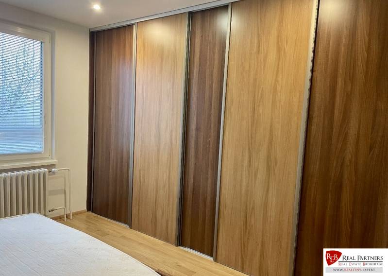 Prenájom 2-izb kompletne zariadený PET FRIENDLY byt BA II - Spálňa 2-izbového bytu s podlahou s dreveným dekorom a vstavanou skriňou.