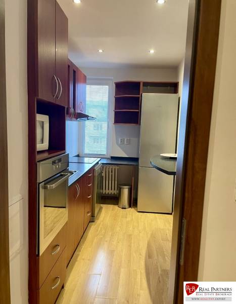 Prenájom 2-izb kompletne zariadený PET FRIENDLY byt BA II - Kuchyňa v 2-izbovom byte s dreveným dekorom podlahy a vstavanými spotrebičmi.