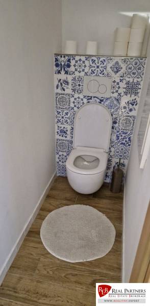 Prenájom 3 - izbový byt Bratislava - Petržalka - Toaleta s modro-bielymi dlaždicami a podlahou s dreveným dekorom v 3-izbovom byte.