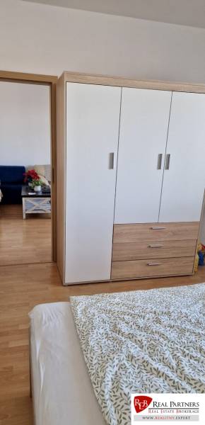 Prenájom 3 - izbový byt Bratislava - Petržalka - Spálňa v 3-izbovom byte s posteľou, skriňou a podlahou s dreveným dekorom.